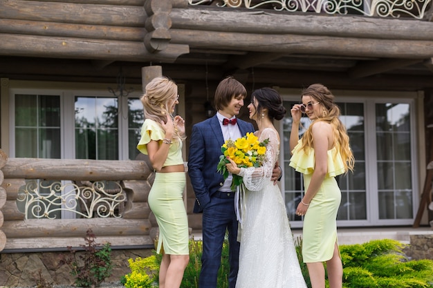 Newly married with bridesmaids on wedding ceremony posing at the villa