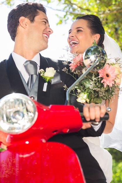 Newlywed couple enjoying scooter ride