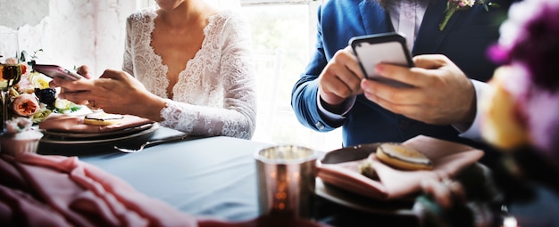 Newlywed couple using mobile phone