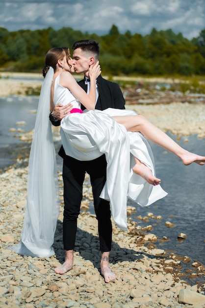 Newlywed couple walking on wedding day outdoor on the field