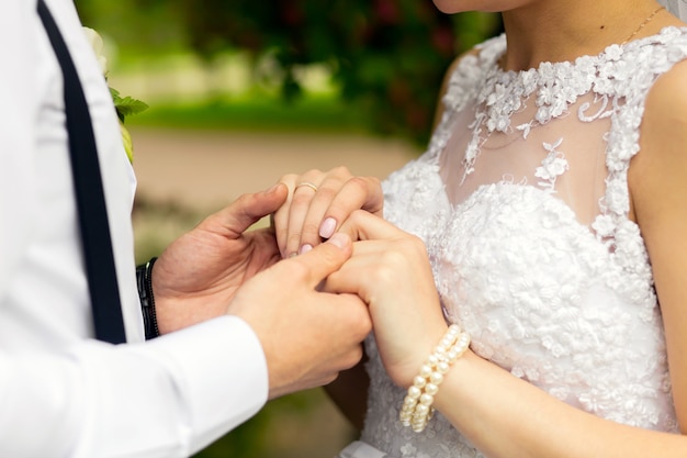 Newlywed couple in wedding dresses holding hands