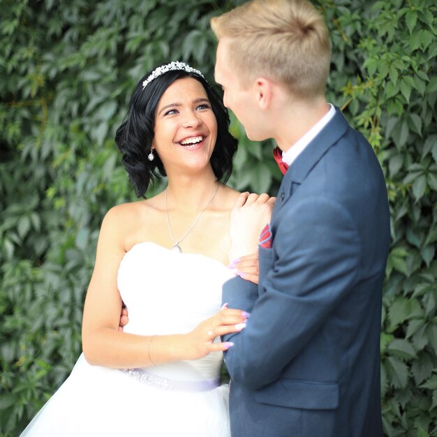 Newlyweds on the background of green leaves