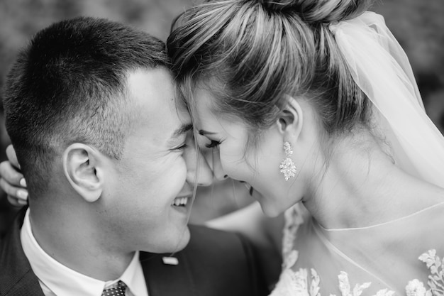 Gli sposi nella fotografia in bianco e nero hanno chiuso gli occhi e hanno chinato la testa. avvicinamento.