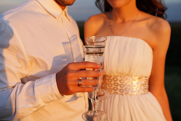 Gli sposi controllano i bicchieri di champagne. bicchieri da sposa con champagne