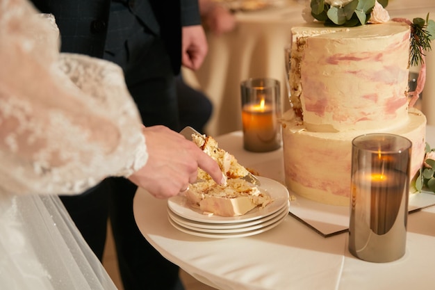 Newlyweds cut off the first piece of wedding cake