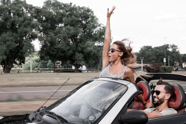 Newlyweds enjoying a trip in a convertible the concept of a successful life style