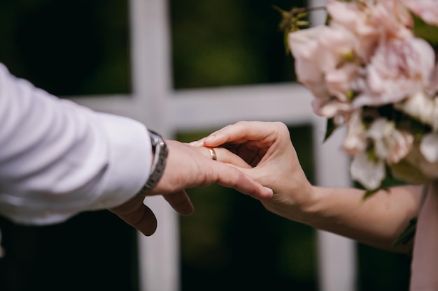 The newlyweds exchange rings, near the wedding arch, at the wedding ceremony.