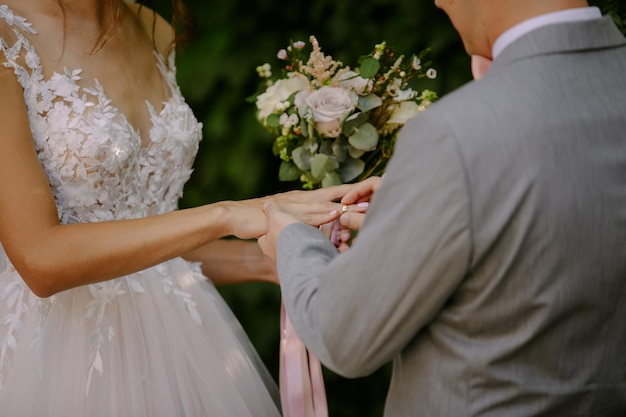 Newlyweds exchange rings near the wedding arch at the wedding ceremony.