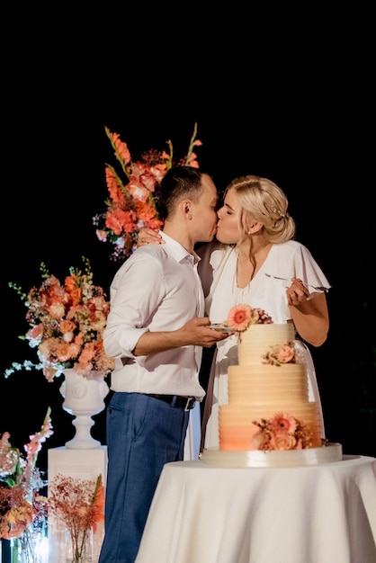 Фото Молодожены с удовольствием разрезают, смеются и пробуют свадебный торт