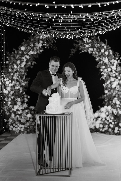 Newlyweds happily cut laugh and taste the wedding cake