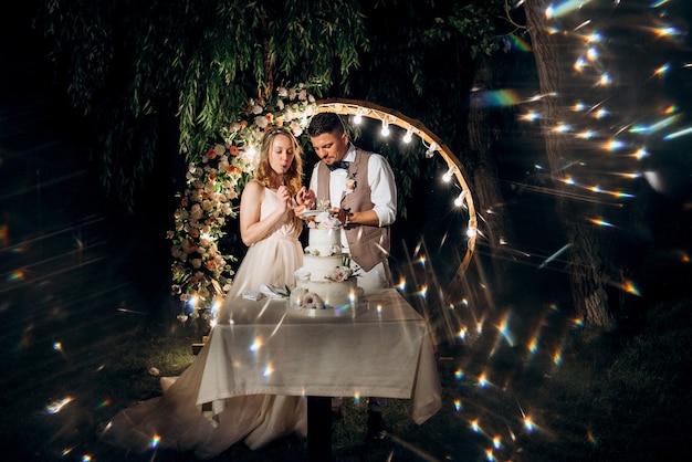 Photo newlyweds happily cut, laugh and taste the wedding cake