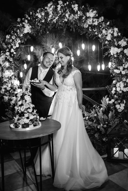 Newlyweds happily cut, laugh and taste the wedding cake