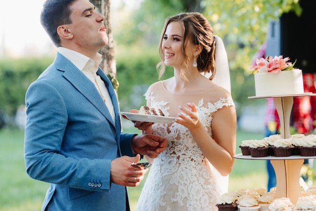 Newlyweds happily cut, laugh and taste the wedding cake