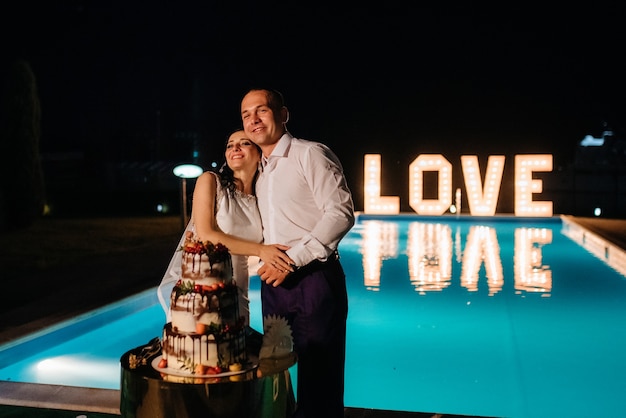 Newlyweds happily cut, laugh and taste the wedding cake