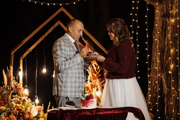 Newlyweds happily cut, laugh and taste the wedding cake