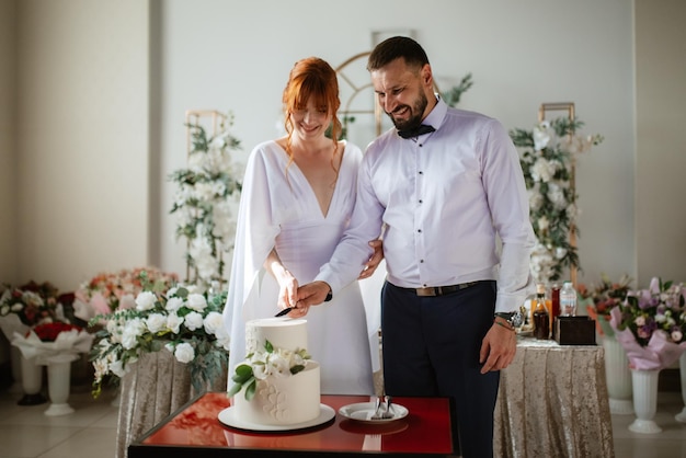 Newlyweds happily cut and taste the wedding cake