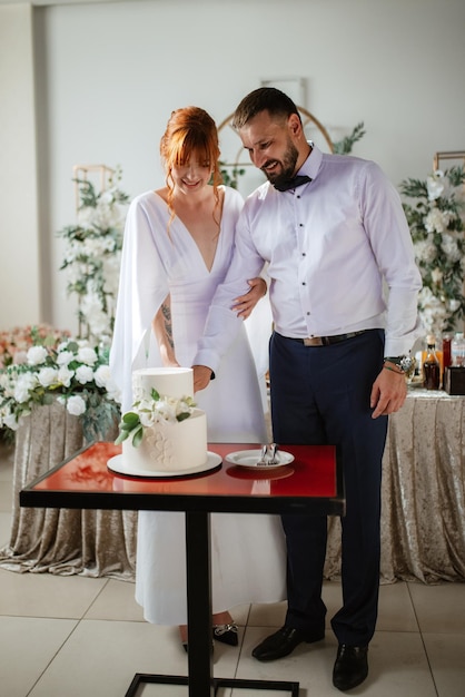 Newlyweds happily cut and taste the wedding cake