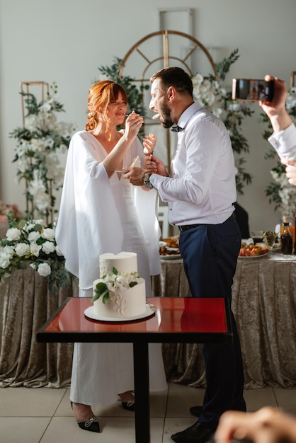 Newlyweds happily cut and taste the wedding cake