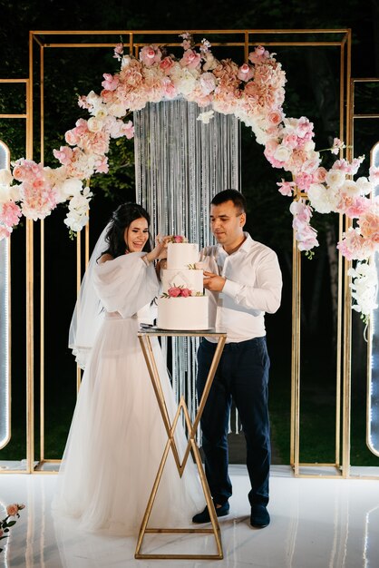 Newlyweds happily cut and taste the wedding cake