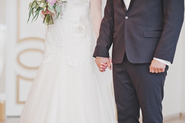 The newlyweds hold hands tightly before saying the most important wor