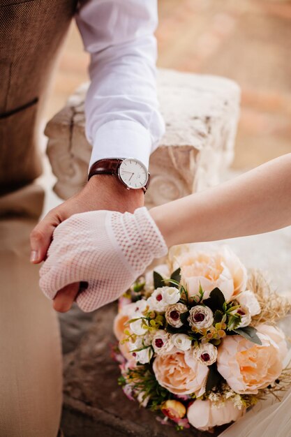 Newlyweds holding wedding bouquet together