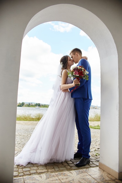 Newlyweds hug and kiss wedding