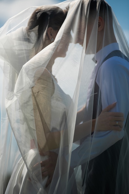 The newlyweds hug tenderly on the wedding day