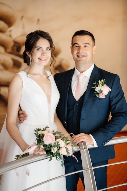 Newlyweds hugging and looking at the camera