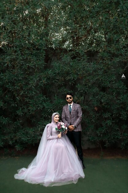 Foto nuovi sposi che posano per un servizio fotografico di matrimonio nel cortile della tenuta