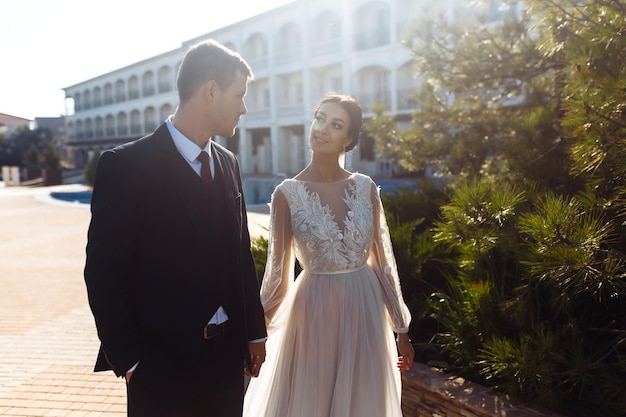 Newlyweds tenderly hug kiss and enjoy each other Walk of lovers Amazing smiling wedding couple Love