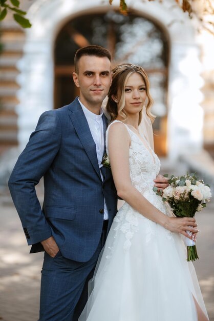 Newlyweds walk in the city near old buildings