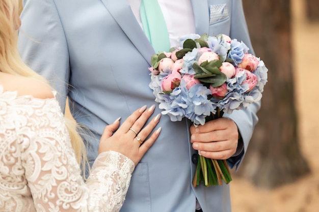 Newlyweds at wedding day, wedding couple with wedding bouquet of flowers, bride and groom