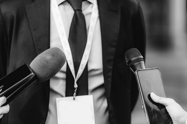 Photo news reporters interviewing a businessman outdoors