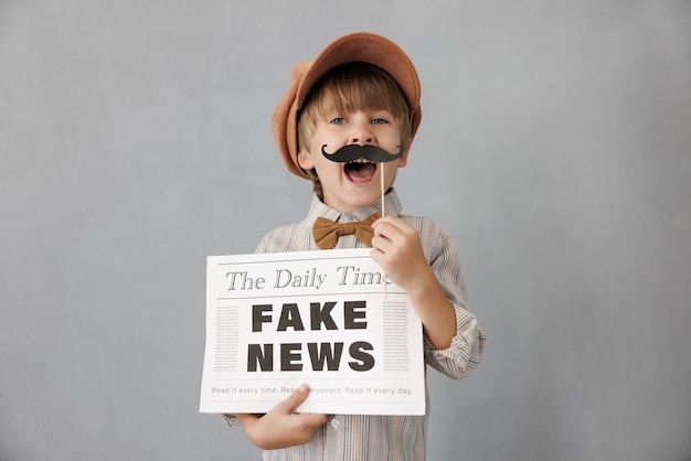 Photo newsboy shouting against grunge wall background boy selling fake news