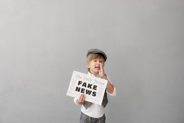 Photo newsboy shouting against grunge wall background boy selling fake news