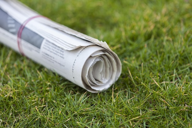 Газета на зеленой траве на открытом воздухе фоне