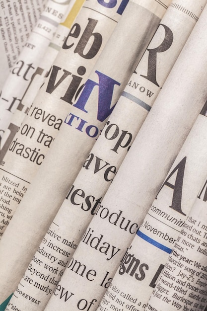 Photo newspaper headlines shown side on in a stack of daily newspapers