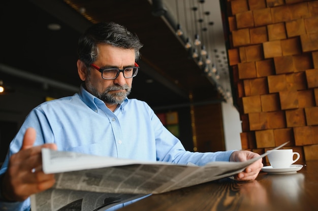 Newspaper in the morning Senior businessman at his office riding newspapers