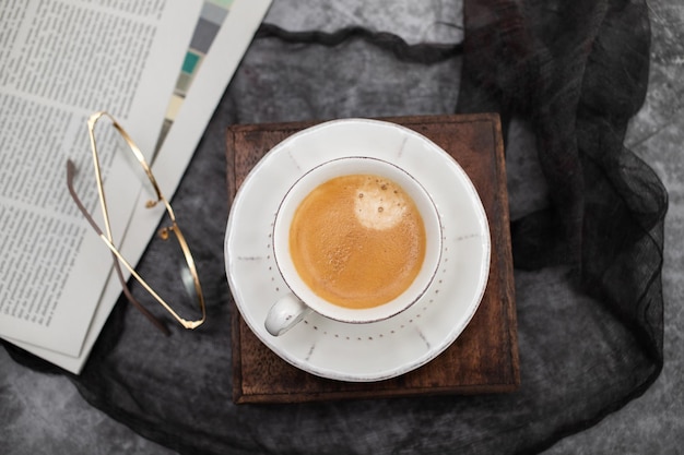 Newspapers and coffee cup with reading glasses