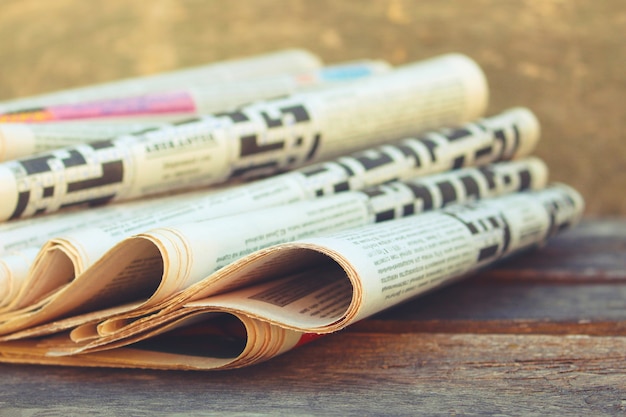 Photo newspapers and magazines on old wood background. toned image.