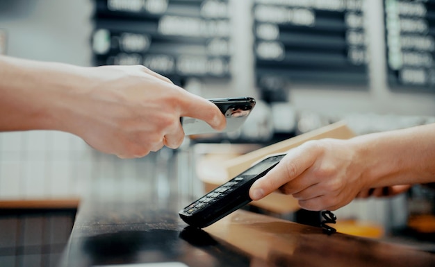 Foto nfc-betaling online vanaf uw telefoon een medewerker verkoopt koffie in een papieren beker of afhaalmaaltijden