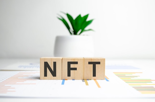 NFT text on wooden blocks as innovation in the digital goods trade concept