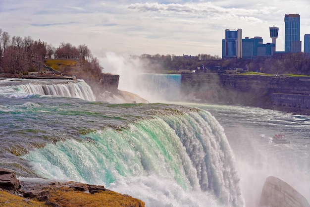 미국 쪽에서 나이아가라 폭포, 캐나다 쪽에서 고층 빌딩. 아메리칸 폭포(American Falls), 브라이들 베일 폭포(Bridal Veil Falls), 염소 섬(Goat Island), 호스슈 폭포(Horseshoe Falls) 및 캐나다 고층 빌딩(Canada Skyscrapers)의 배경을 볼 수 있습니다.