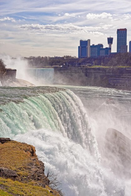 Niagara Falls vanaf de Amerikaanse kant en Skyscrapers vanaf de Canadese kant. Een zicht op American Falls, Bridal Veil Falls, Horseshoe Falls en Canadese wolkenkrabbers op de achtergrond.