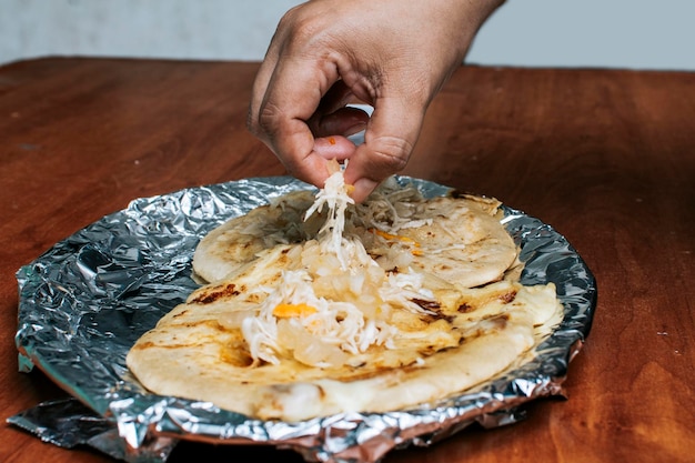 Nicaraguaanse pupusas met salade op aluminiumfolie Uitzicht op heerlijke Salvadoraanse pupusas geserveerd op houten tafel Traditionele pupusas geserveerd met salade op tafel