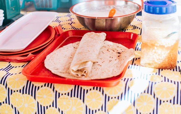 Photo nicaraguan quesillo made and served on the table traditional quesillo with pickled onion and wrapped tortilla traditional nicaraguan quesillo food traditional large quesillo served on table