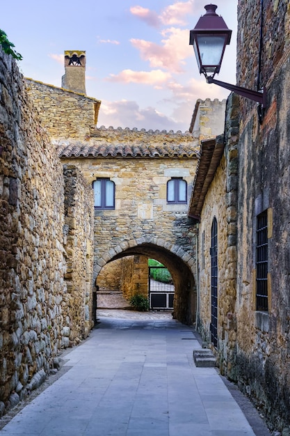 Nice alley with medieval houses and arched passageways under the buildings Peratallada Girona Spain