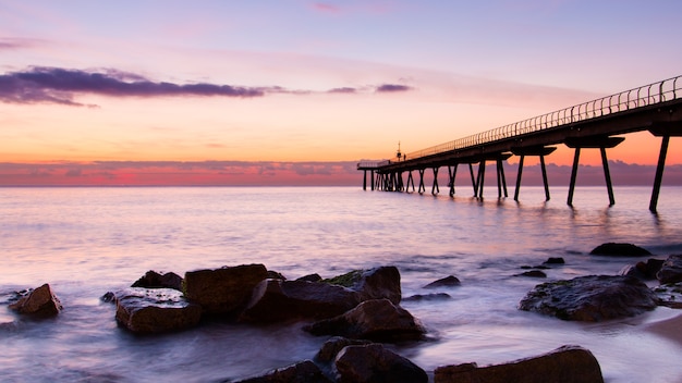 Nice awakening of sky with few clouds and sea next to a walkway