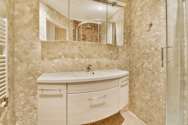 Хорошая ванная комната с огромным зеркалом и раковиной