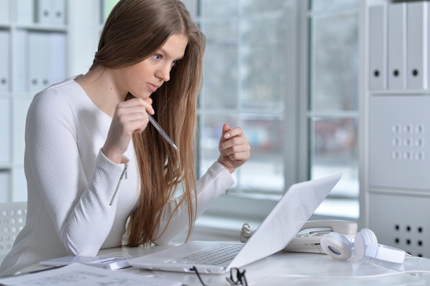 Nice business woman sitting at table with laptop